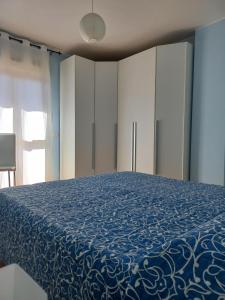 a bedroom with a bed with a blue blanket at A un passo da... B&B in Elmas