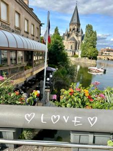 a bench with the word love written on it next to flowers at L’Antre du Graoully Metz Centre in Metz