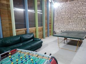 sala de estar con mesa de ping pong y sofá en le Guimapé, en Assay