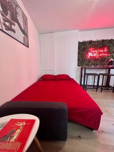 a bedroom with a red bed and a table at L’Antre du Graoully Metz Centre in Metz