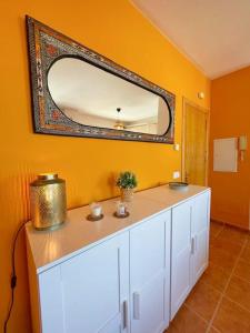 La salle de bains est pourvue d'un miroir sur un mur jaune. dans l'établissement Modern, bright and comfortable apartment with shared roof terrace, à Canillas de Aceituno