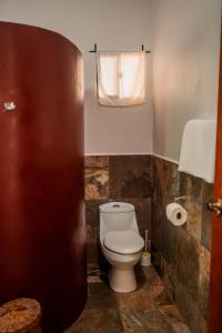 a bathroom with a toilet and a toilet paper roll at Hotel Jardín Garden de Granada Nicaragua in Granada