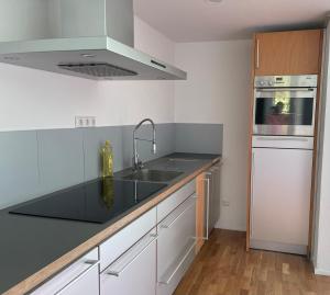 a kitchen with a sink and a stove top oven at Bungalow in ruhiger Siedlung mit Terrasse und Stellplatz in Landshut +7 photos
