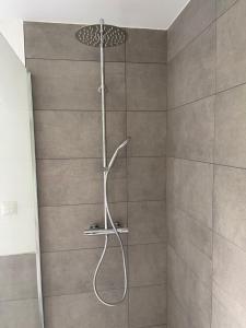 a shower with a shower head in a bathroom at Bungalow in ruhiger Siedlung mit Terrasse und Stellplatz in Landshut