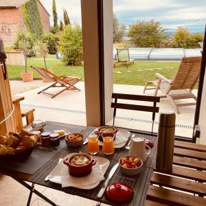 a table with food and drinks on a patio at Suite intimiste insolite et luxueuse avec Spa Privatif- jacuzzi, vue de rêve in Cintegabelle