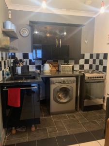 a kitchen with a washing machine and a stove at Daiches Braes Brunstane Portobello in Edinburgh