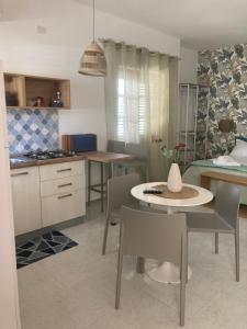 una cucina e una sala da pranzo con tavolo e sedie di Villa Chiara a Mazara del Vallo