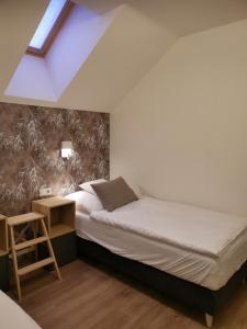 Dormitorio pequeño con cama y mesa en Apartmány Benedicta, en Benešov