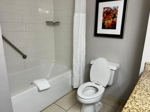 a bathroom with a white tub and a toilet and a sink at The Branson Hillside Hotel in Branson