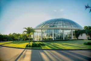 ein großes Glasgebäude mit einer Palme davor in der Unterkunft Ceylonta Beach Resort in Hambantota