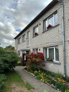 a brick house with flowers in front of it at Medus in Ventspils