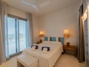 a bedroom with two beds and a window at Casa Casita in Cala Saona +29 photos