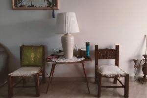 stół z dwoma krzesłami i lampką w obiekcie Casa con impronta vintage a Nartë 