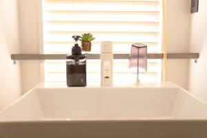 a bathroom sink with a soap dispenser and a window at ZONK HOTEL Haruyoshi-Teramachidori in Fukuoka