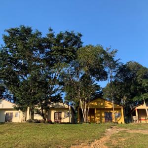 una casa con un árbol delante de ella en Chalés Recanto en Guaraciaba do Norte