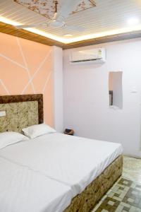 een slaapkamer met een groot wit bed in een kamer bij sun guest house in Ujjain