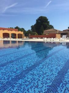 una gran piscina con sillas blancas en Maisonnette eau turquoise en Argelès-sur-Mer