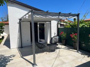 a pergola with two chairs and a table on a patio at OliveUm Apartments in Umag