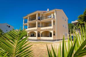 BanjolにあるApartment Villa Alba Rabの前にヤシの木がある建物