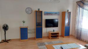 - un salon avec une télévision à écran plat et des placards en bois dans l'établissement Ribere Apartment, à Pärnu