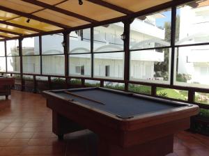 a pool table in a room with windows at Pylea Beach Hotel in Ialysos