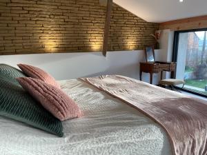 a bedroom with a bed with pillows and a brick wall at Suite intimiste insolite et luxueuse avec Spa Privatif- jacuzzi, vue de rêve in Cintegabelle