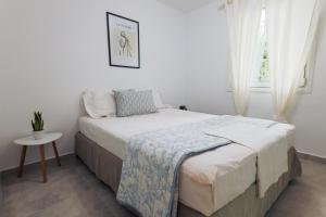 a bedroom with a bed and a table and a window at Zeusplace Seaside Home private beach and parking in Plaka Litochorou