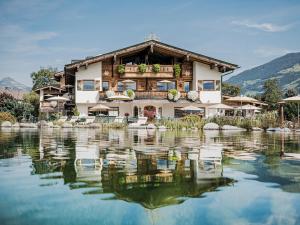 a house sitting on top of a lake at Aparthotel Stacherhof in Fügen