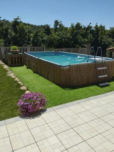 a swimming pool in a yard with flowers at Taoretto 1 in Serravalle delle Langhe