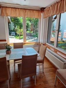 a dining room with a table and chairs and windows at 7 Levél Central Apartments in Miercurea-Ciuc