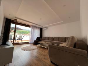 a living room with a couch and a large window at Zani Boutique Hotel in Prizren