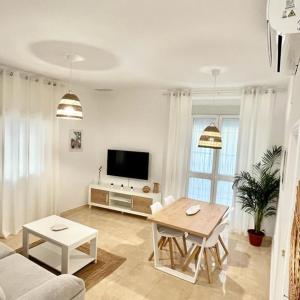 een woonkamer met een bank en een tafel bij Apartamento las tres lunas in Sanlúcar de Barrameda
