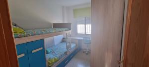 エステポナにあるPiso Esteponaの二段ベッド2台、デスクが備わる客室です。