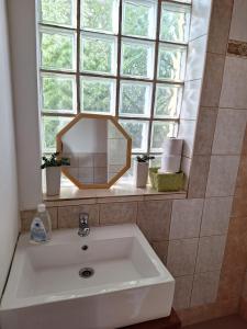 a bathroom sink with a mirror and a window at Sunset House Piestany Bungalow in Banka