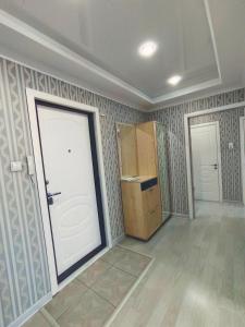 Habitación con puerta blanca y nevera. en Апартаменты формата Люкс в Центре г.Семей, en Semey