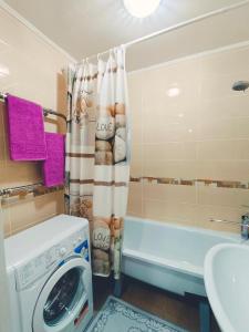een badkamer met een wasmachine en een bad bij Апартаменты формата Люкс в Центре г.Семей in Semey