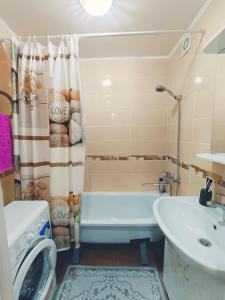 a bathroom with a tub and a sink and a shower at Апартаменты формата Люкс в Центре г.Семей in Semey