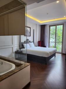 - une chambre d'hôtel avec un lit et une baignoire dans l'établissement Feliz Hotel Binh Duong, à Thu Dau Mot