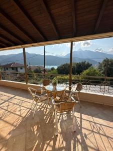 a table and chairs on a patio with a view of mountains at Nisos family apartments in Yénion