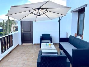 a patio with a table and an umbrella at Canto Rojo, La Asomada con vistas a Lobos in La Asomada