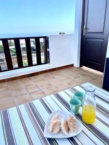 a table with a plate of pastries and orange juice at Canto Rojo, La Asomada con vistas a Lobos in La Asomada