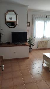 - un salon avec une télévision et un miroir mural dans l'établissement Casa Celita, à Poio 3 autres photos