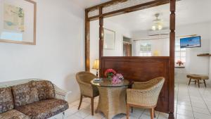 Edwards Guesthouse في Sandy Ground Village: غرفة معيشة مع طاولة وأريكة