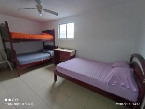 a bedroom with a bed and a bunk bed at Hostal SAMARY in Atacames