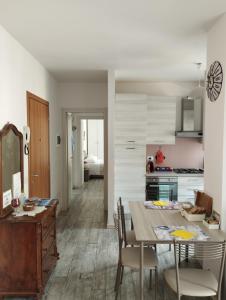 Appartamento Miro في سان بيليغرينو تيرمي: مطبخ وغرفة طعام مع طاولة وكراسي