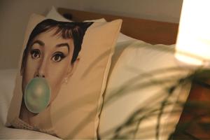 a pillow with a picture of a woman with a green nose at goom Hotel Nakasu in Fukuoka