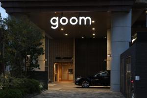 a building with a car parked in front of a door at goom Hotel Nakasu in Fukuoka