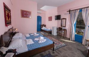 Postel nebo postele na pokoji v ubytování Arolithos Traditional Village Hotel