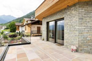 un orsacchiotto seduto su un patio fuori da una casa di Villa In Montagna - Caldes - Val Di Sole a Caldes