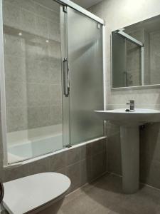 y baño con ducha, lavabo y aseo. en HOTEL FAMILIAR MAXIMINA, en Sallent de Gállego